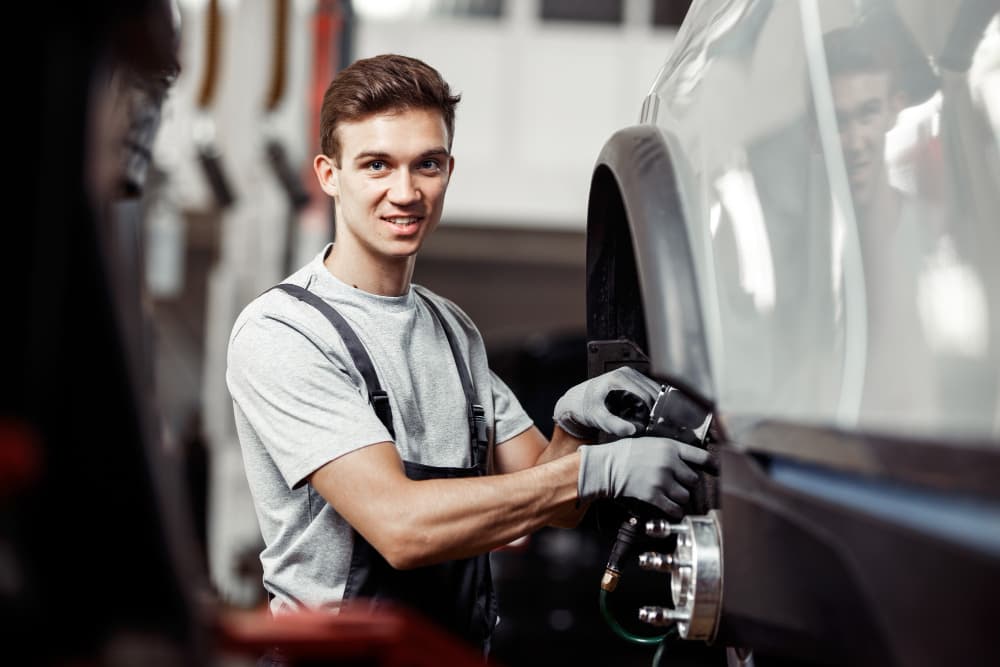 A man is meticulously working on fixing a car wheel.